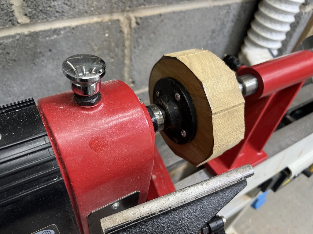 The African teak blank mounted on the lathe using a faceplate