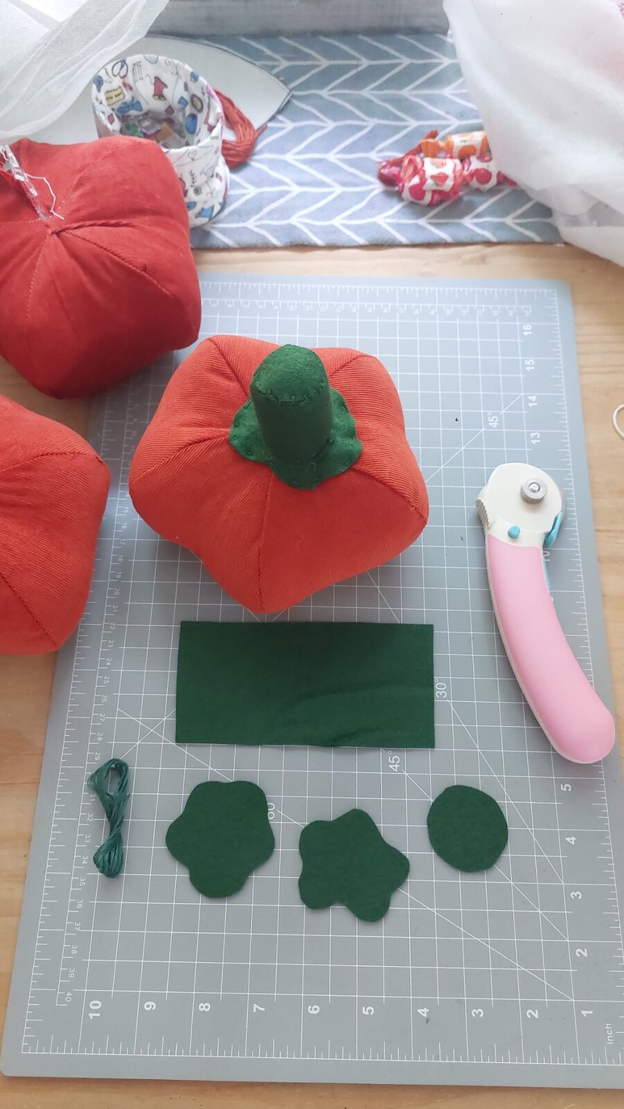 A corduroy pumpkin with a green felt stalk and felt pieces ready to cut