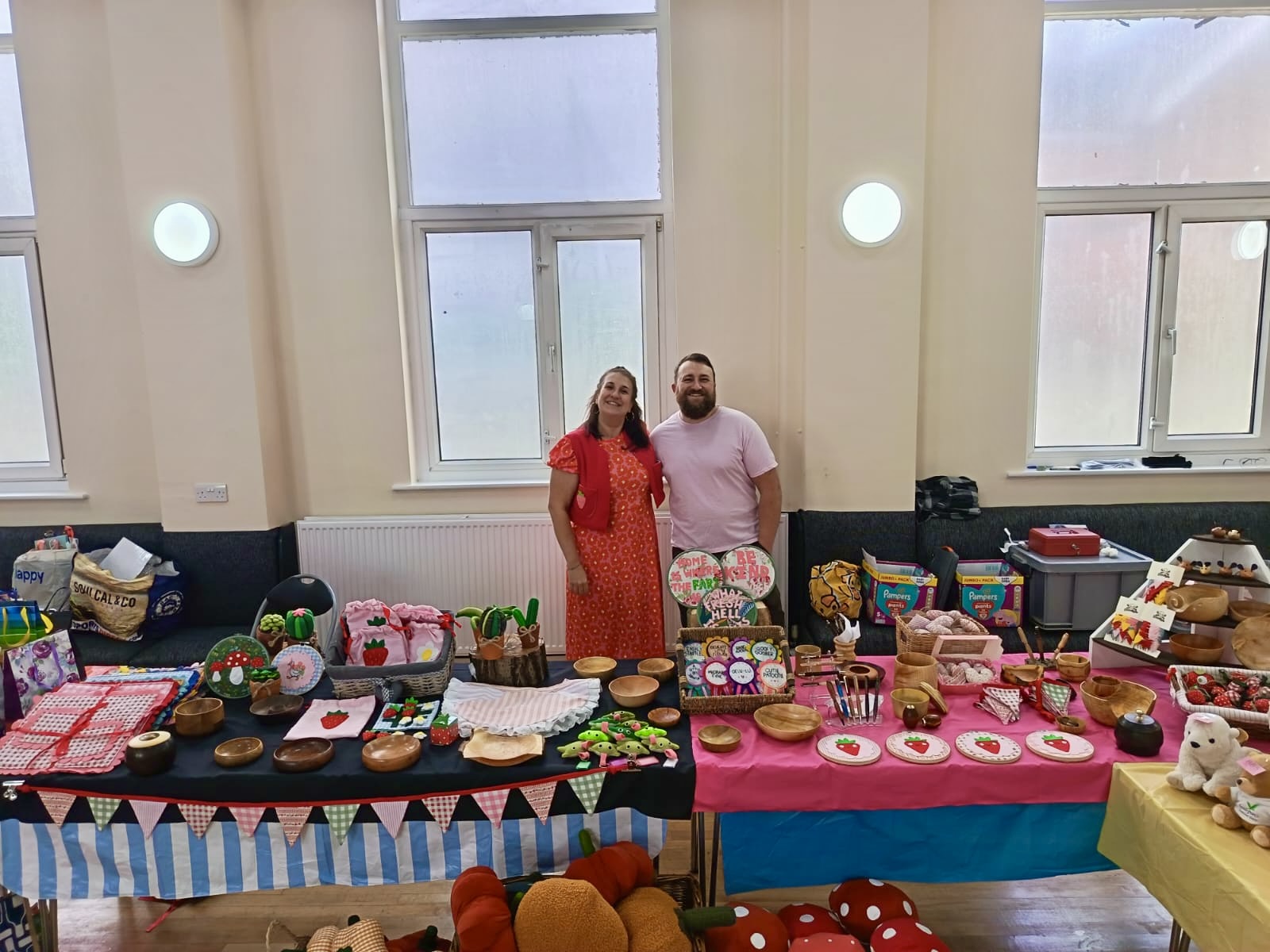 Robyn and Aiden standing behind the Sticks and Giggles stall at Healey Community Centre